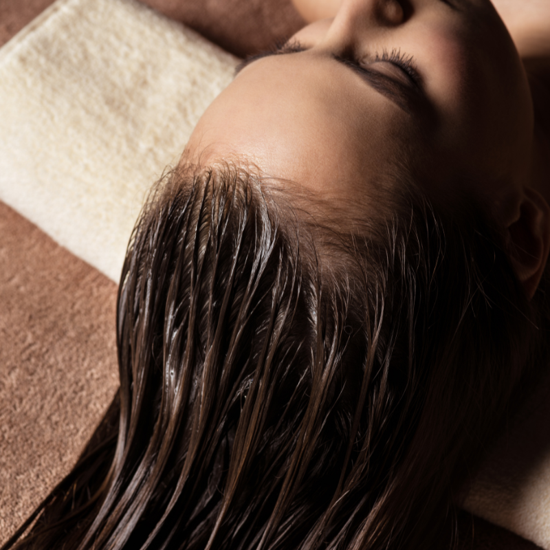 Eine Frau mit nassen Haaren liegt auf einem Handtuch