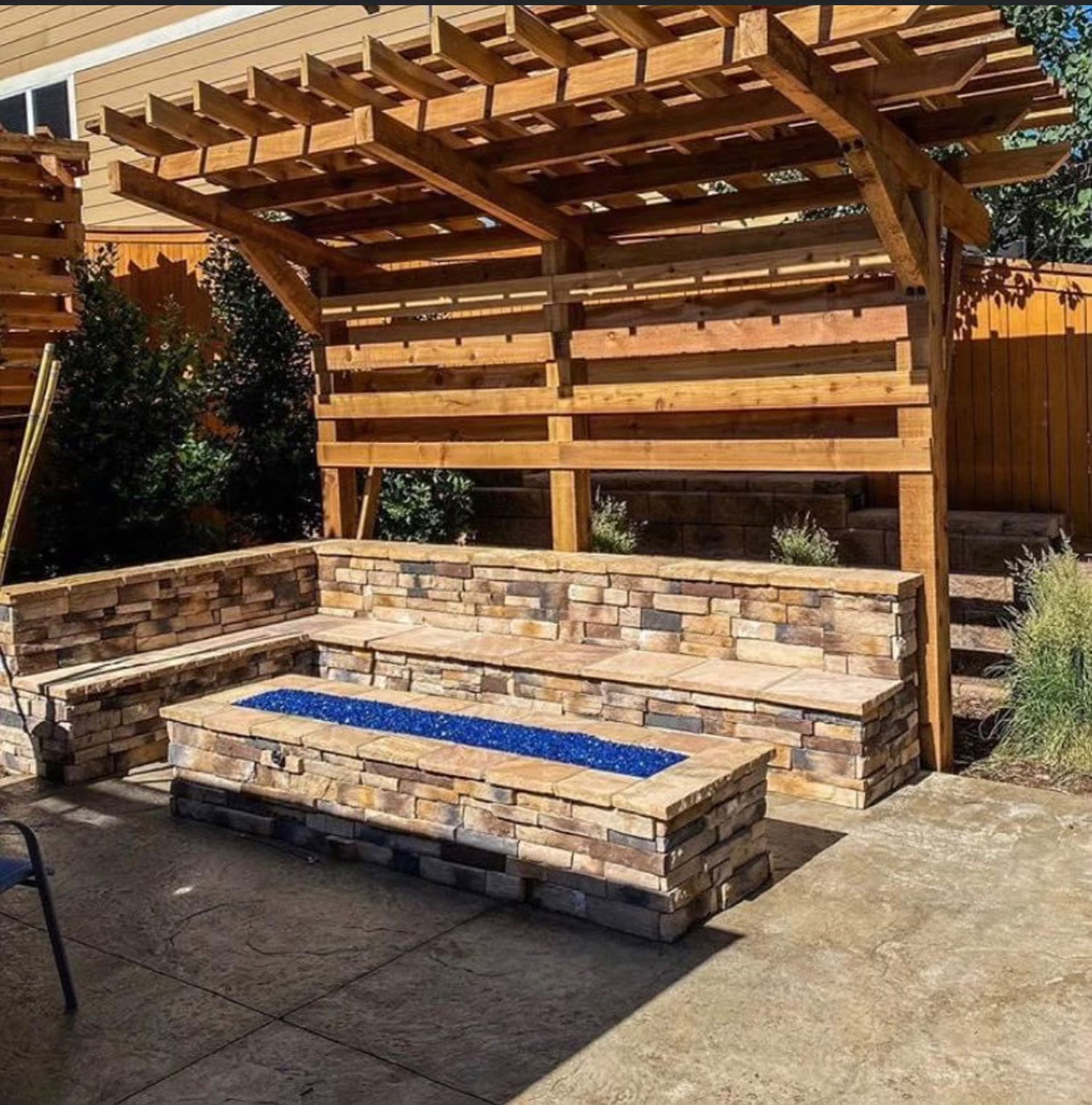 A patio with a fire pit and a wooden pergola