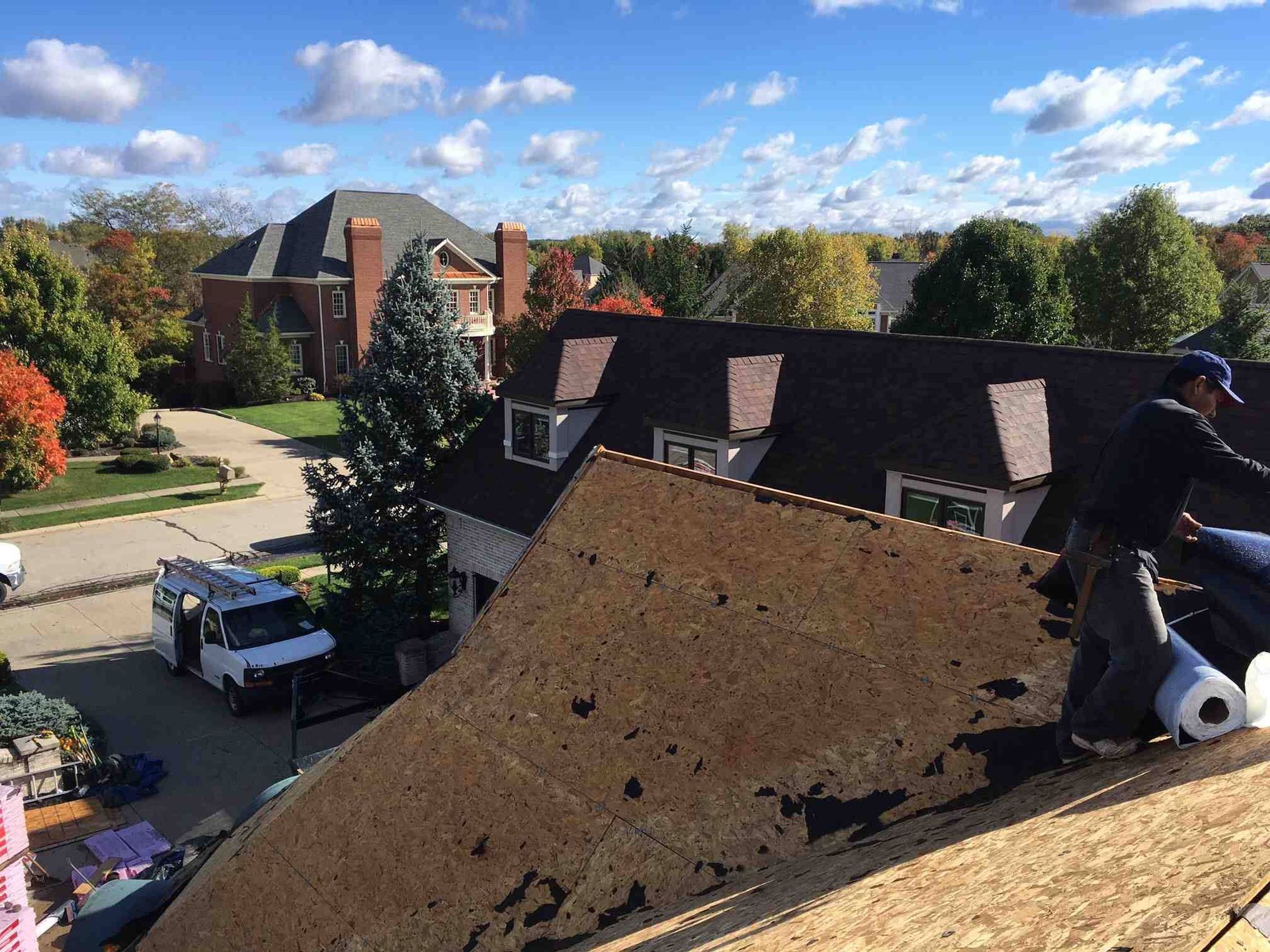 A man is working on the roof of a house.
