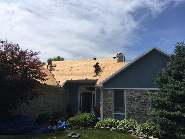 A man is working on the roof of a house.