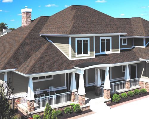 A large house with a brown roof and a large porch