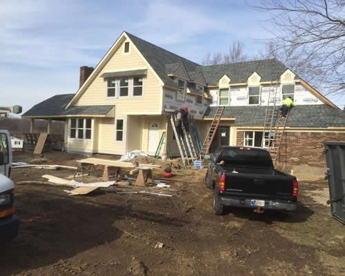 A truck is parked in front of a house under construction.