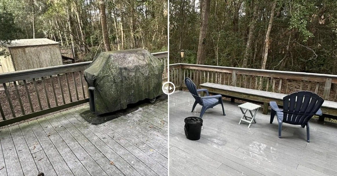 Snow-dusted wooden deck with a grill, railing, blue chair, small table, and potted plant overlooking trees