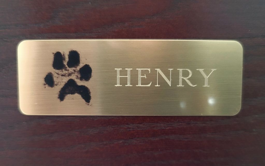 A name tag for henry with a paw print on it