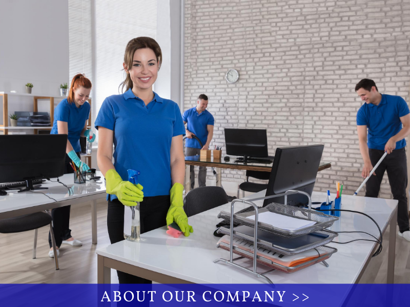 Cleaning crew in blue shirts tidying an office with computers and desks