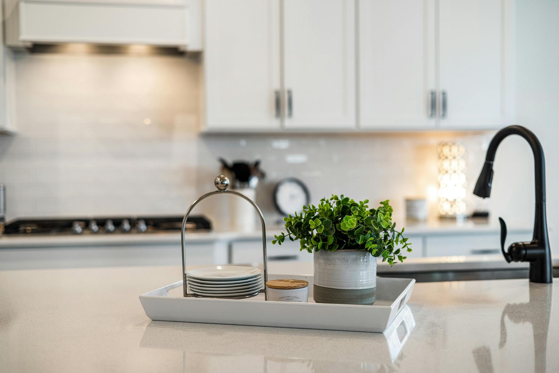Bright modern kitchen with a tray, potted plant, and coffee maker on the counter