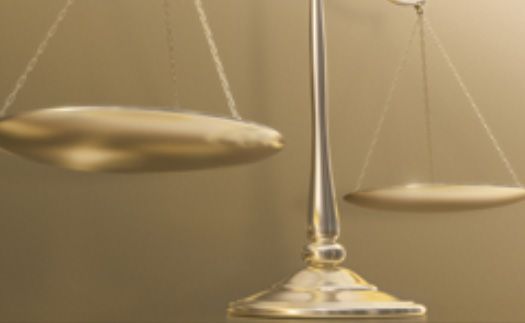 Gold balance scales, one side weighed down, representing imbalance.