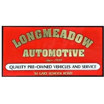 Red sign for Longmeadow Automotive with gold text, advertising quality pre-owned vehicles and service, established 1959, with address.