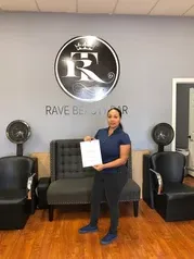 Woman under logo with certificate | Sylmar, CA | Rave Beauty Bar