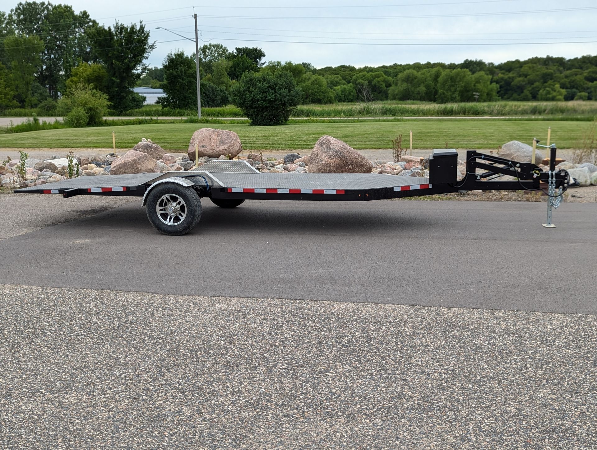 Black utility trailer with a jack.