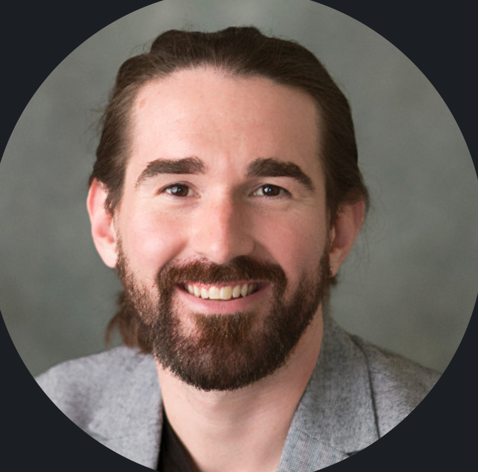 A man in a plaid shirt is smiling for the camera.