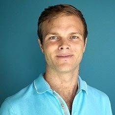A man in a plaid shirt is smiling for the camera.