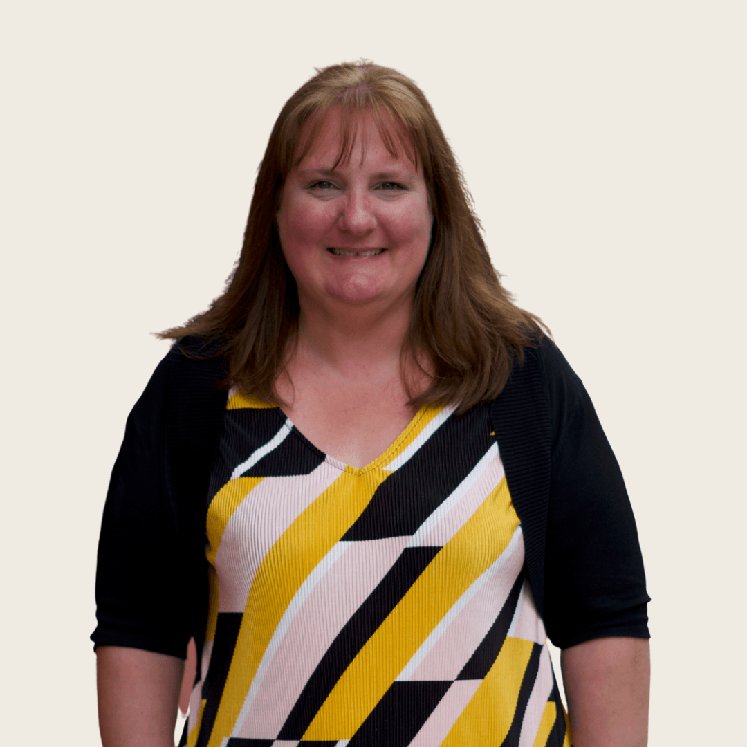 A woman in a yellow and black striped dress smiles for the camera