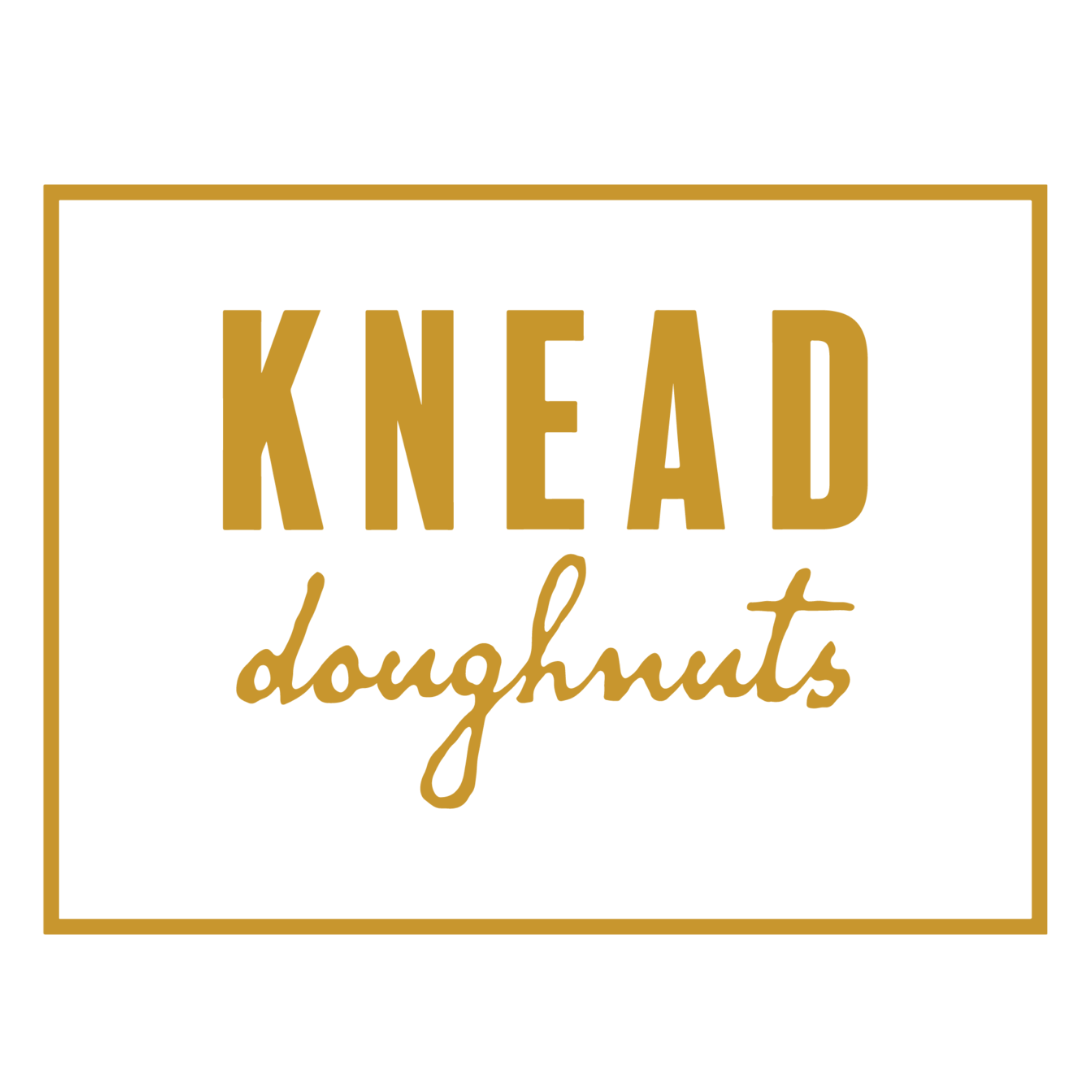 a logo for knead doughnuts in gold on a white background