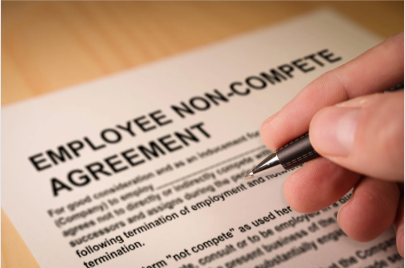A person is signing an employee non compete agreement