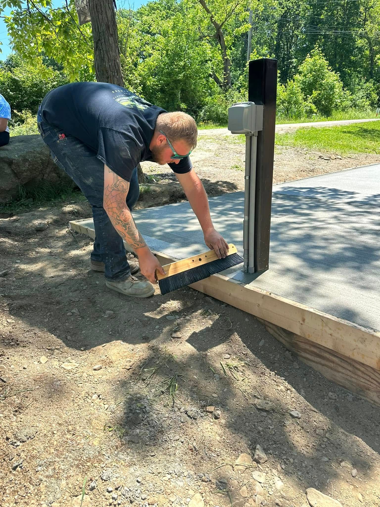 Newly poured concrete slab; two people stand nearby.