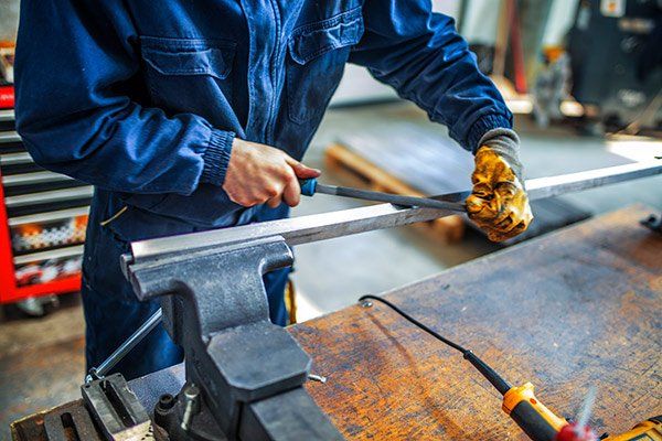 person filing a metal rod