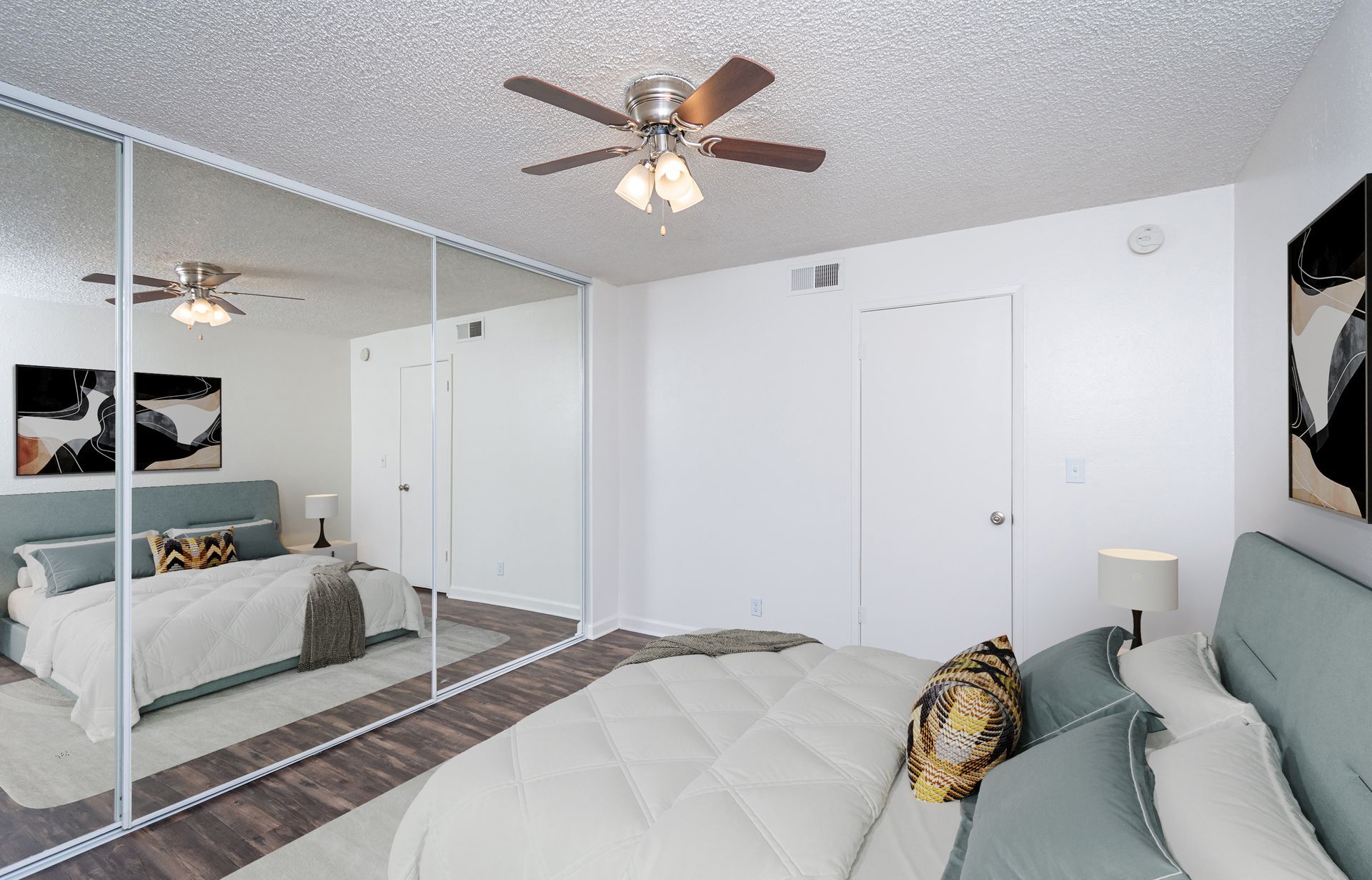 A bedroom with a bed and a ceiling fan