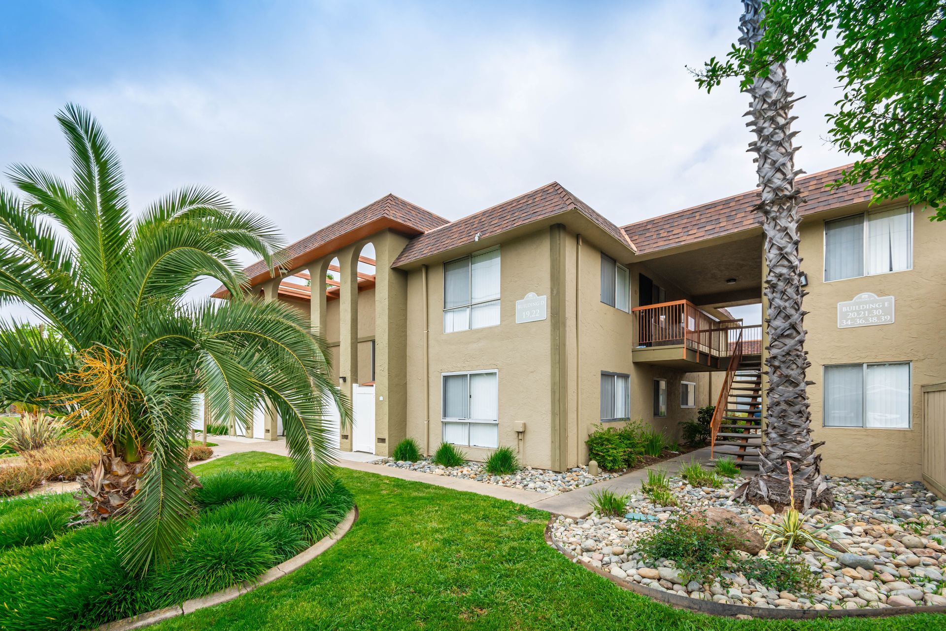 A large apartment building with a palm tree in front of it.