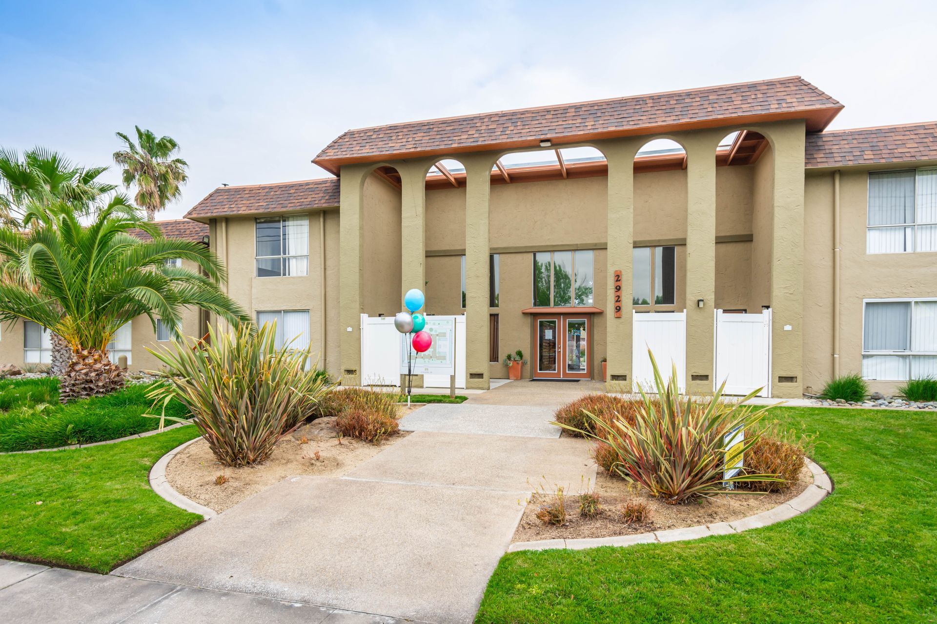 A large building with columns and balloons in front of it.