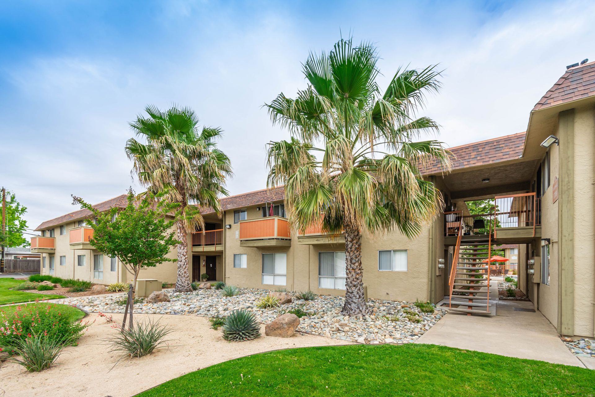 A large apartment building with palm trees in front of it