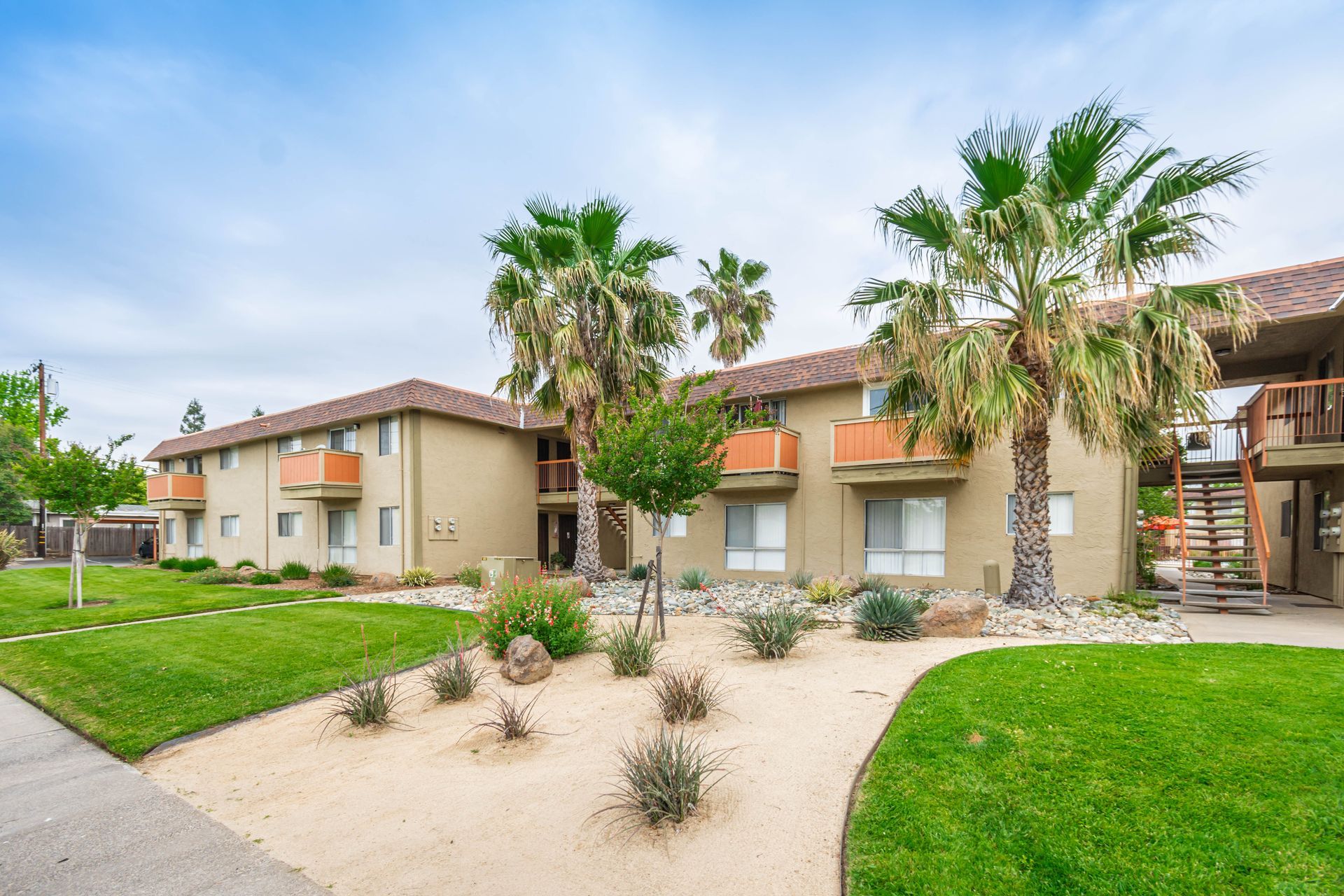 A large apartment building with palm trees in front of it.