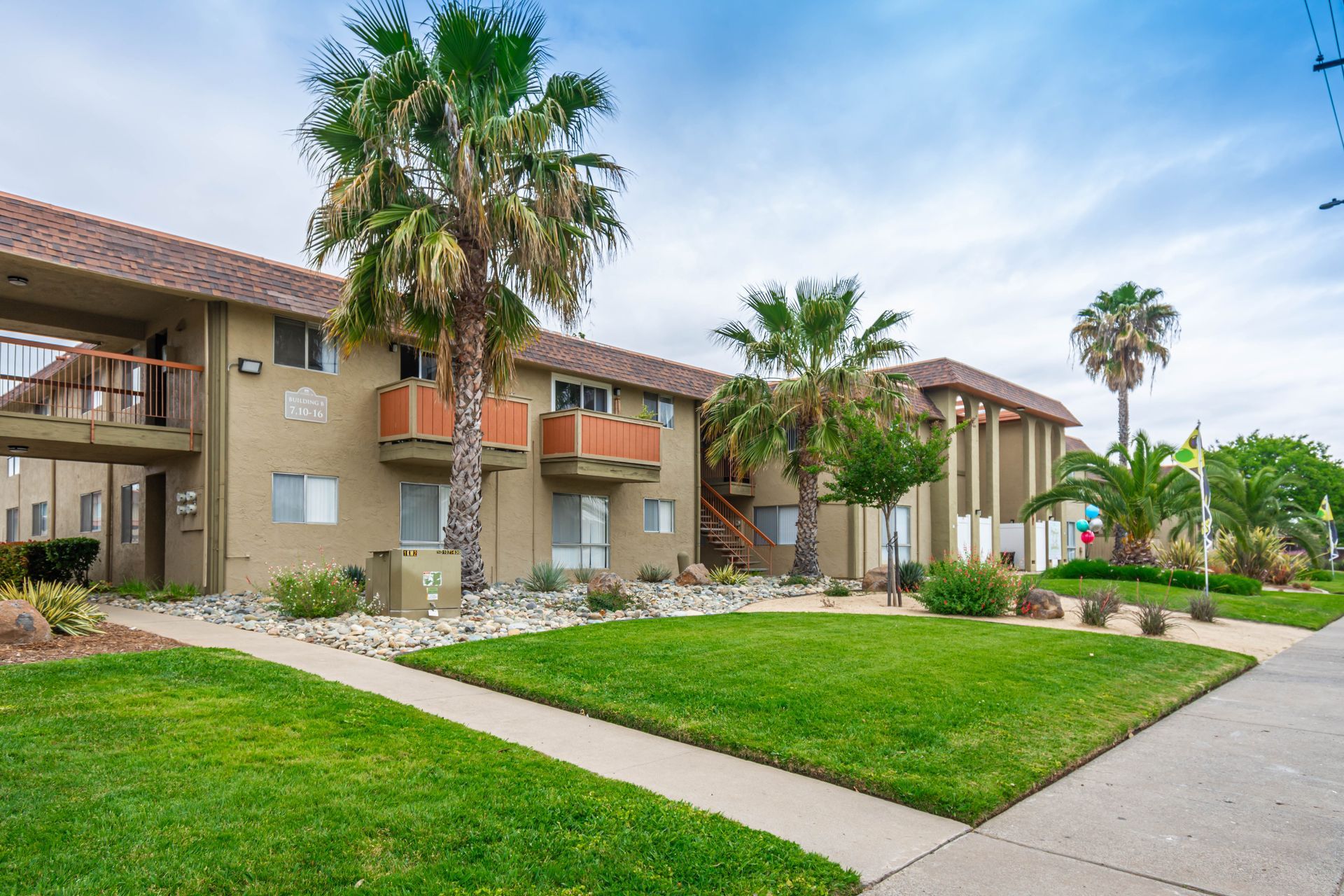 A row of apartment buildings with palm trees in front of them