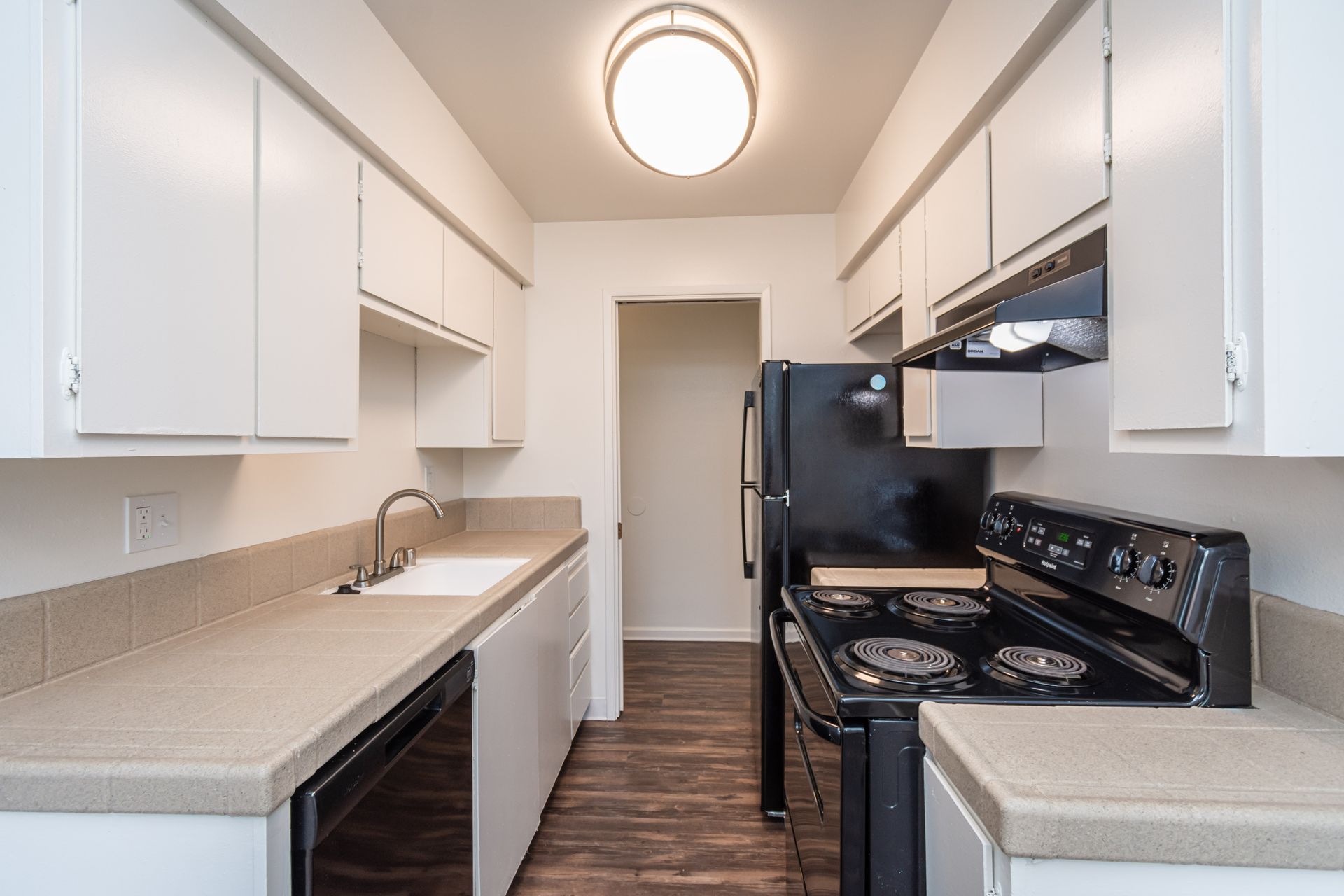 A kitchen with white cabinets and a black stove top oven