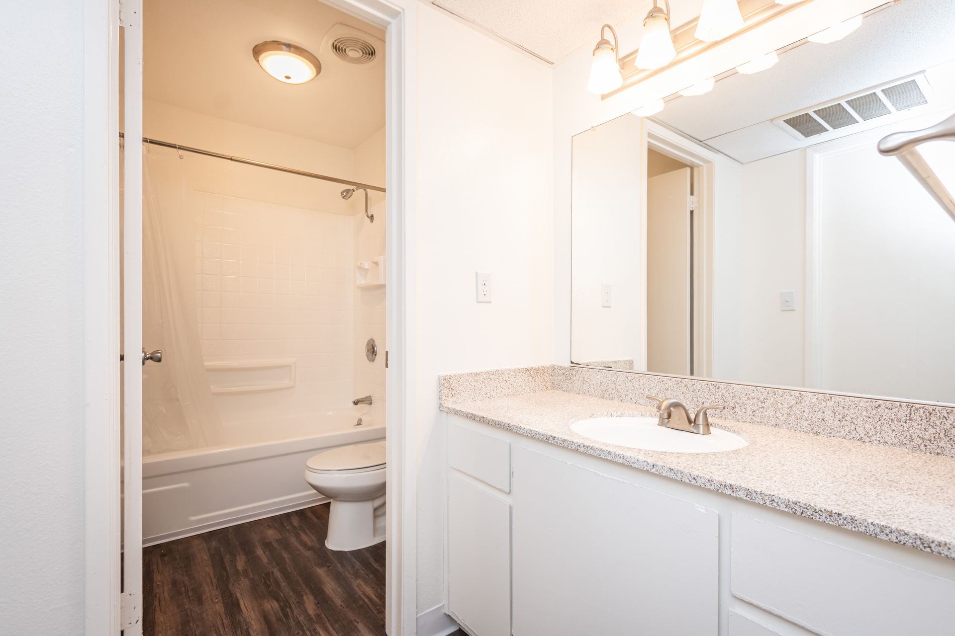A bathroom with a sink , toilet , bathtub and mirror.