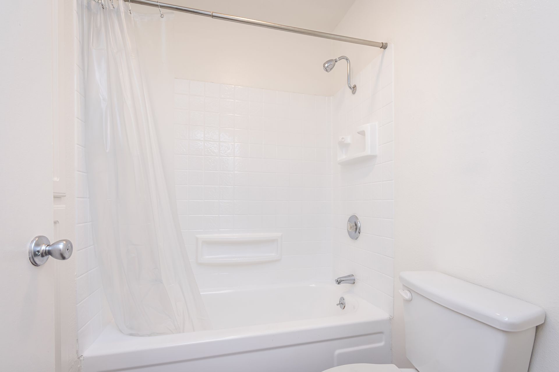 A bathroom with a toilet , bathtub and shower.