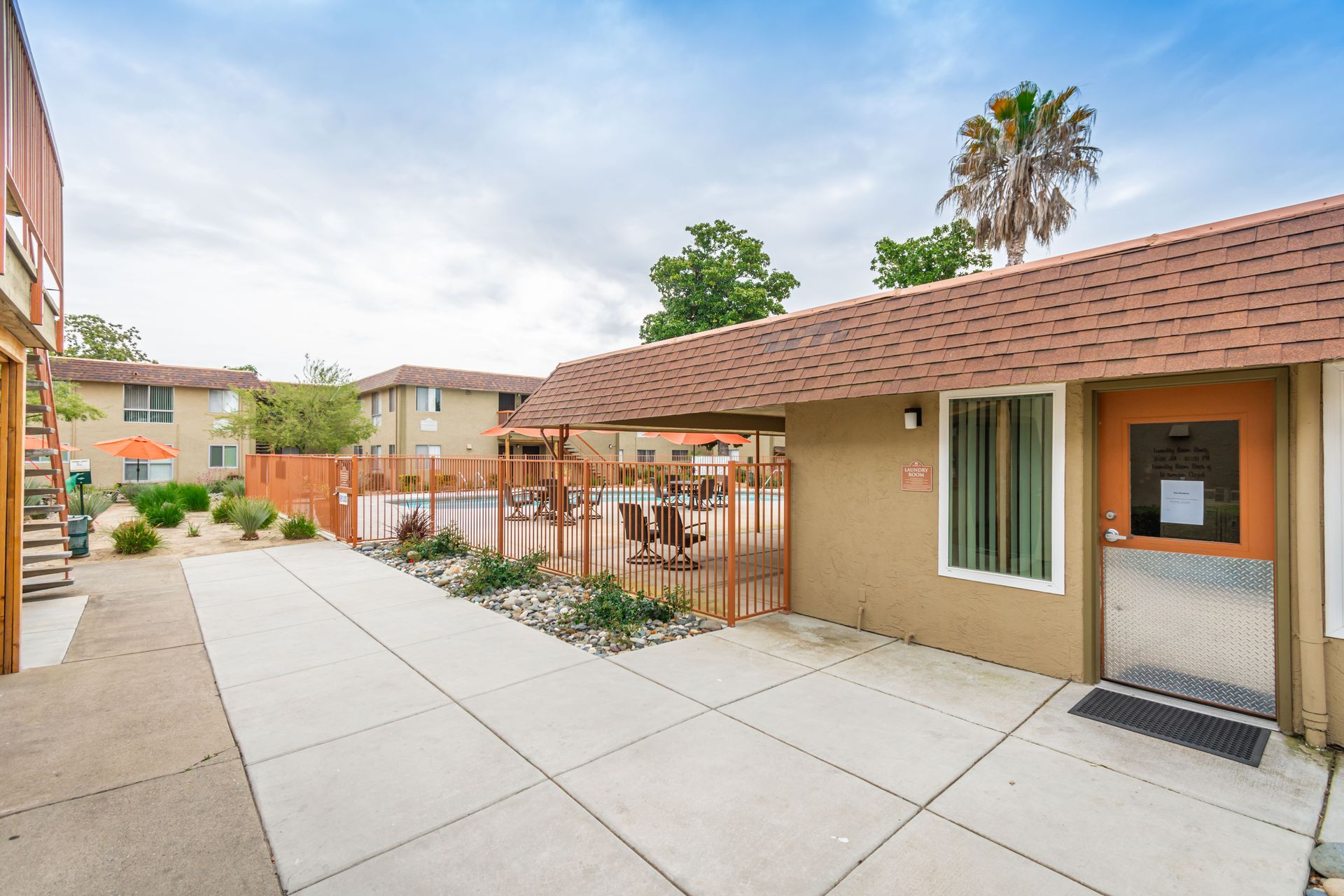 A building with a fence around it and a patio in front of it.