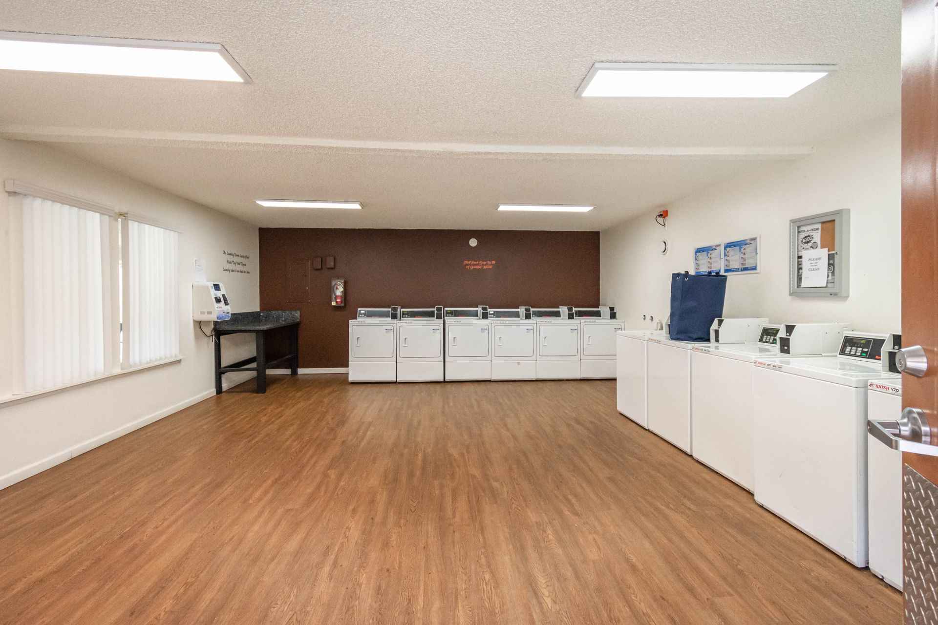 A laundromat with wooden floors and white appliances