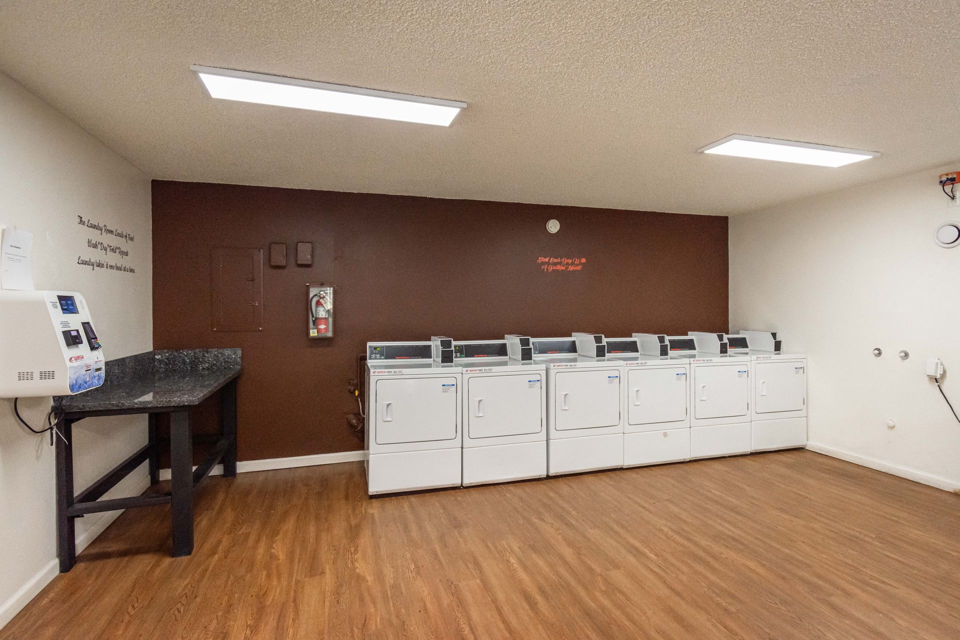 A laundry room with a lot of washers and dryers