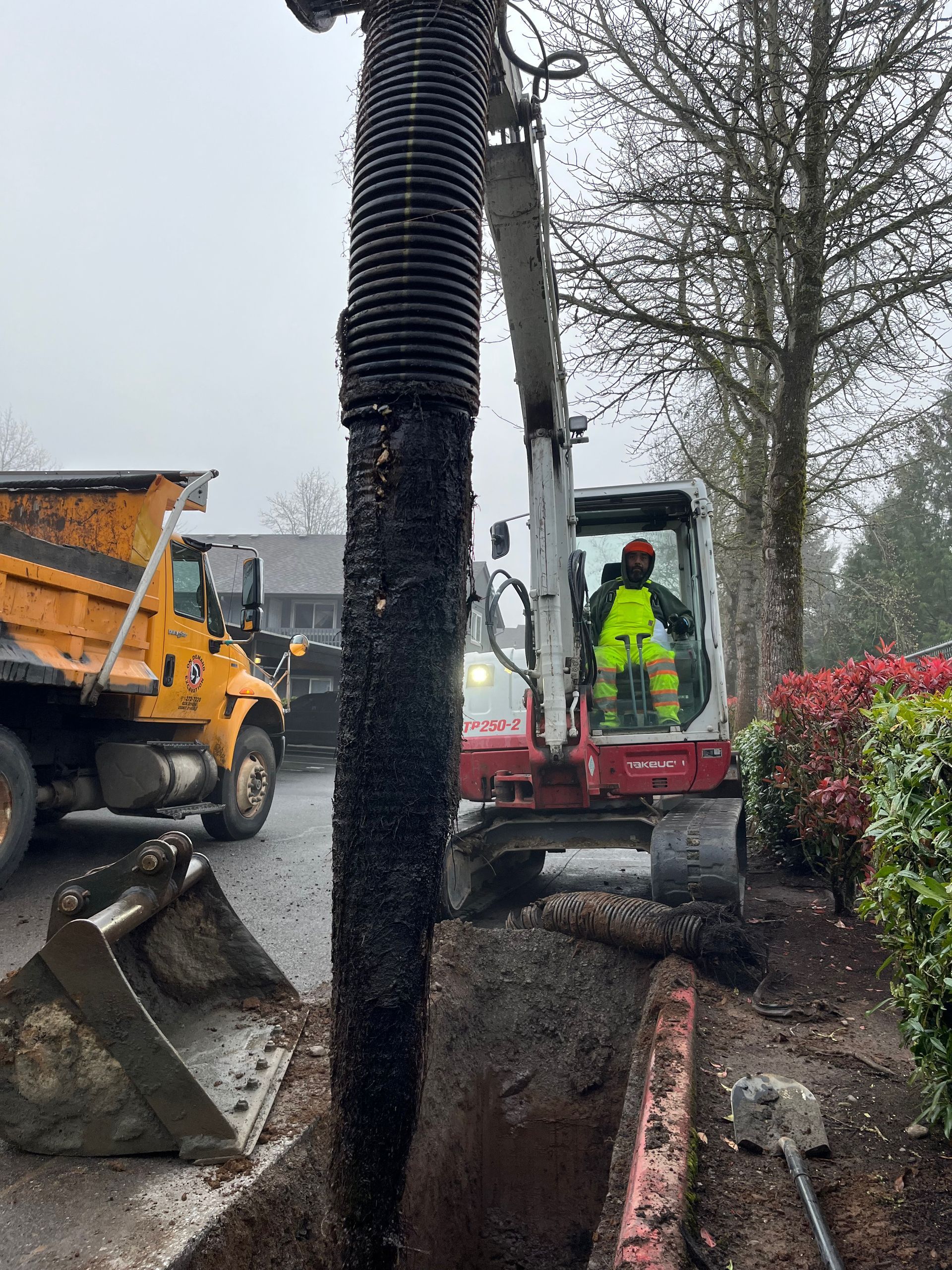 A bathroom with a lot of pipes and a box on the floor.