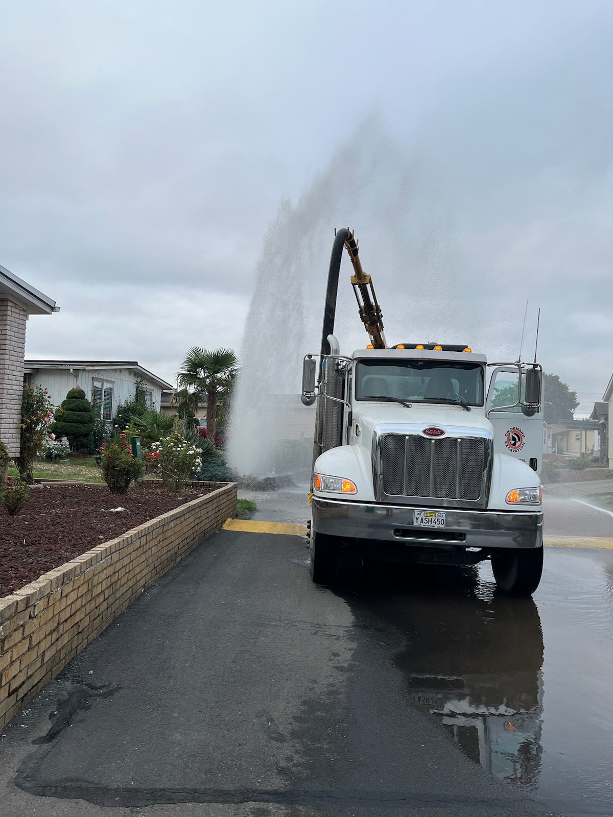 A yellow and black hammer is sitting in a hole in the ground.