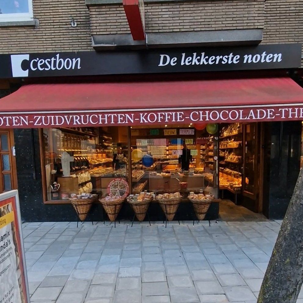 Een winkelpui met een rode luifel waarop staat de lekkerste noten