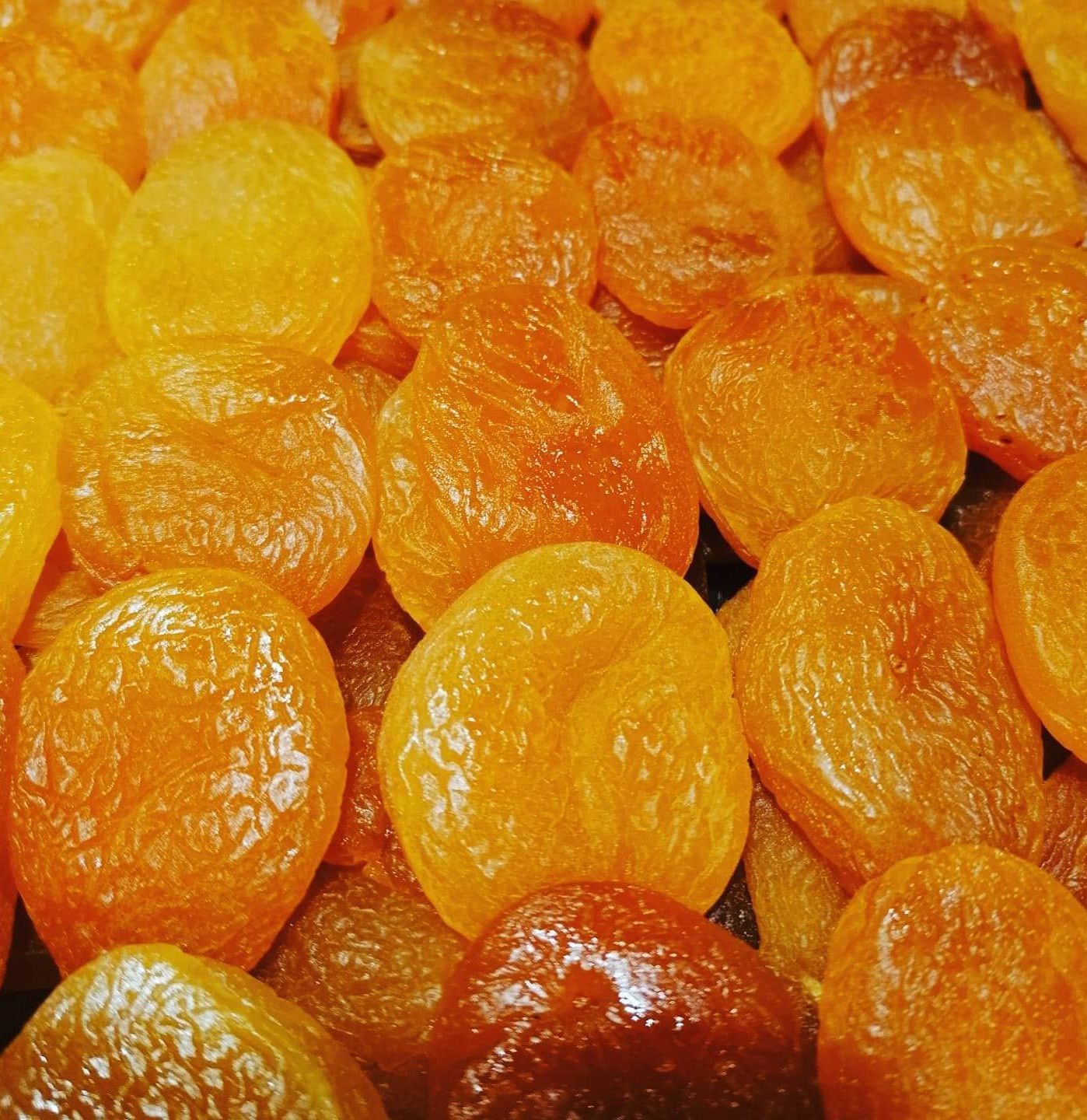 Een close-up van een stapel gedroogde abrikozen op een tafel.