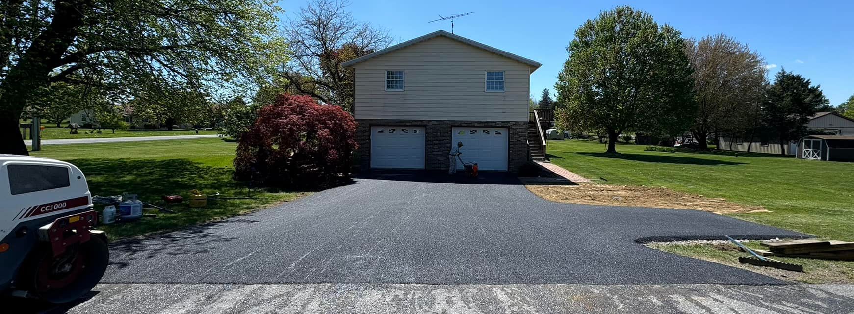 A house with two garages and a driveway in front of it.