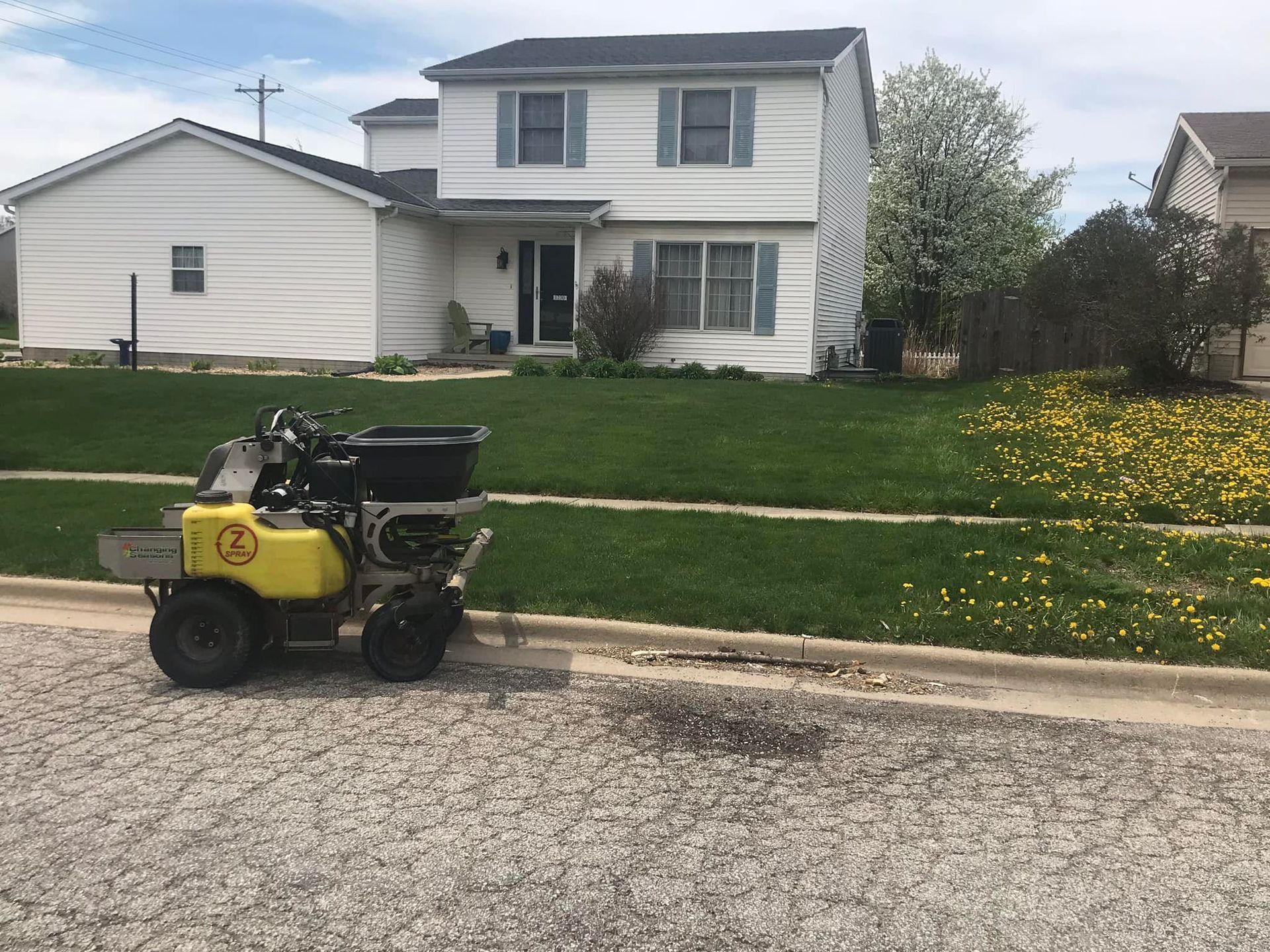 Green John Deere utility vehicle pulling a seeding machine on a grass field.
