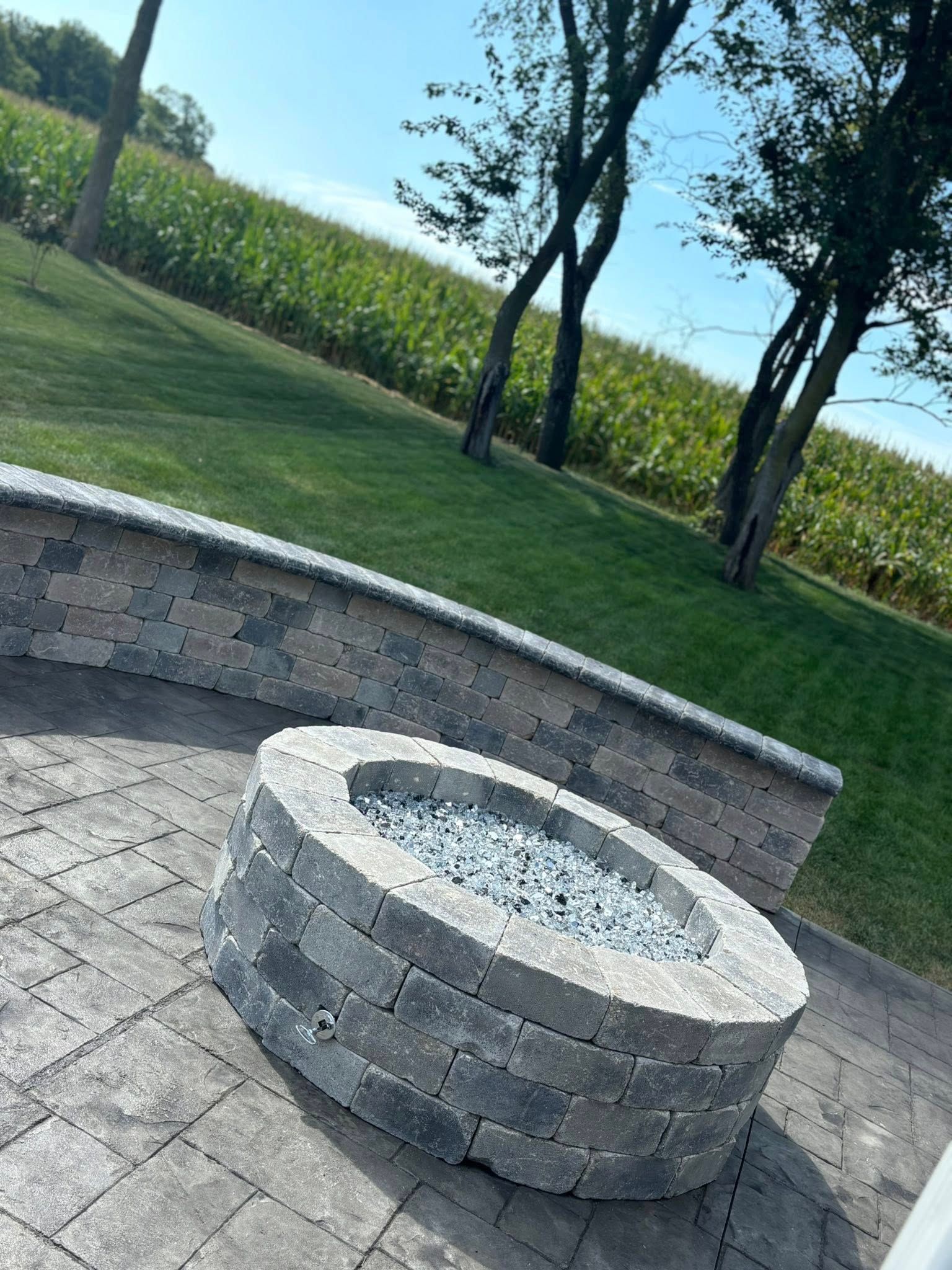 Two workers installing landscaping fabric near a house. One kneels rolling the fabric, other works nearby.
