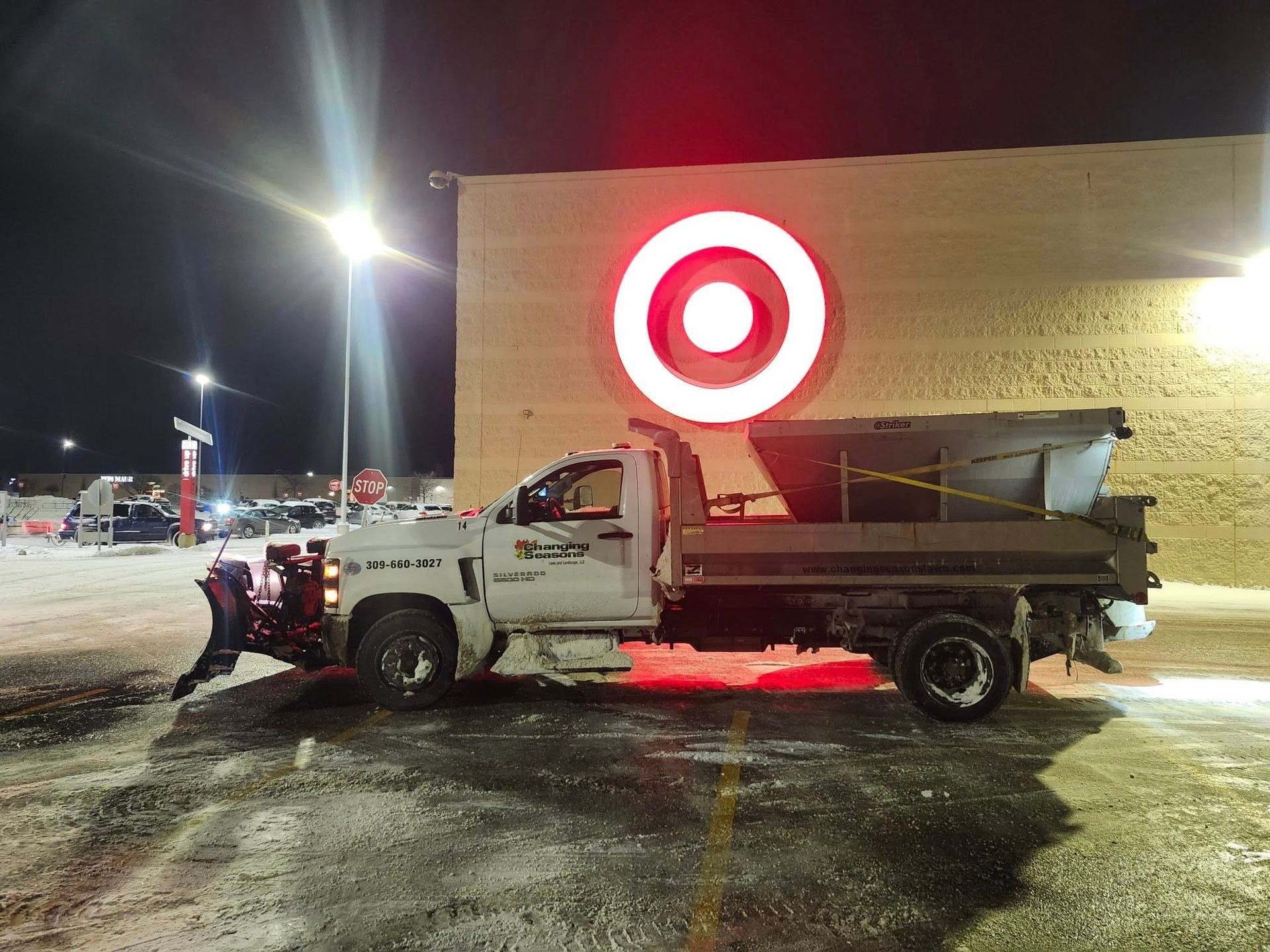Brick and wood facade of a house with a path leading to the wooden front doors. Green bushes line the path.