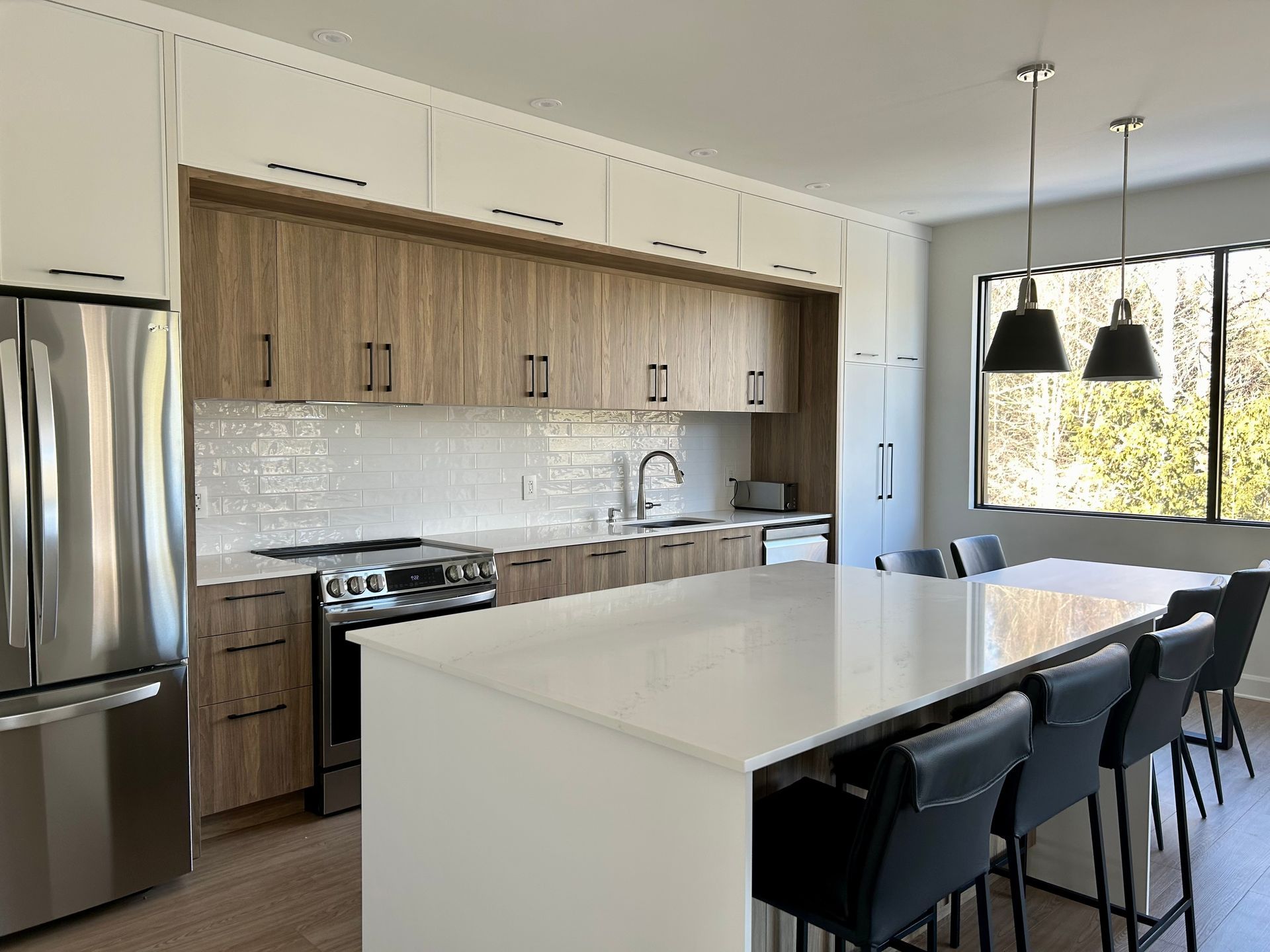 A kitchen with stainless steel appliances , wooden cabinets and a large island.