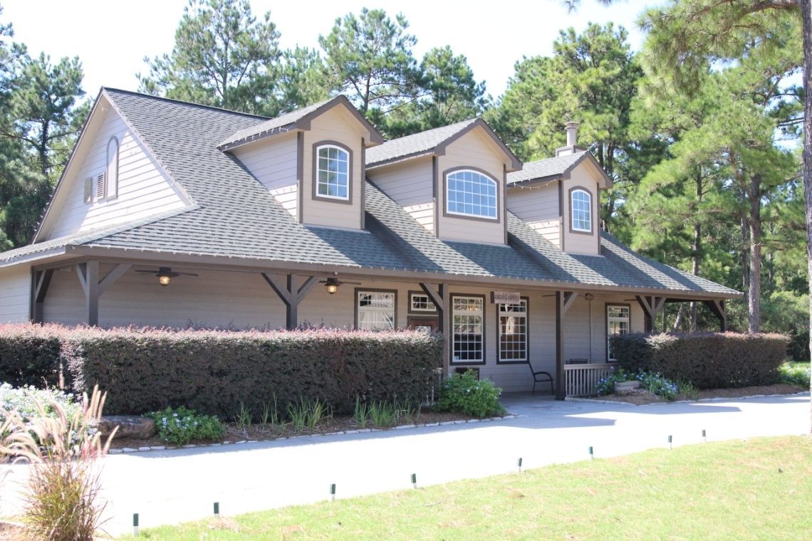 A house with a lot of windows is surrounded by trees