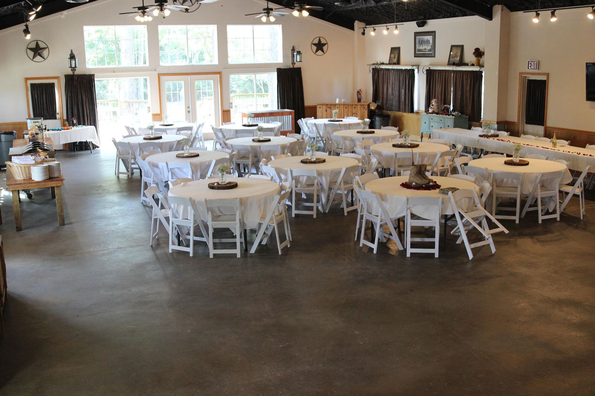A large room with tables and chairs set up for a wedding reception.