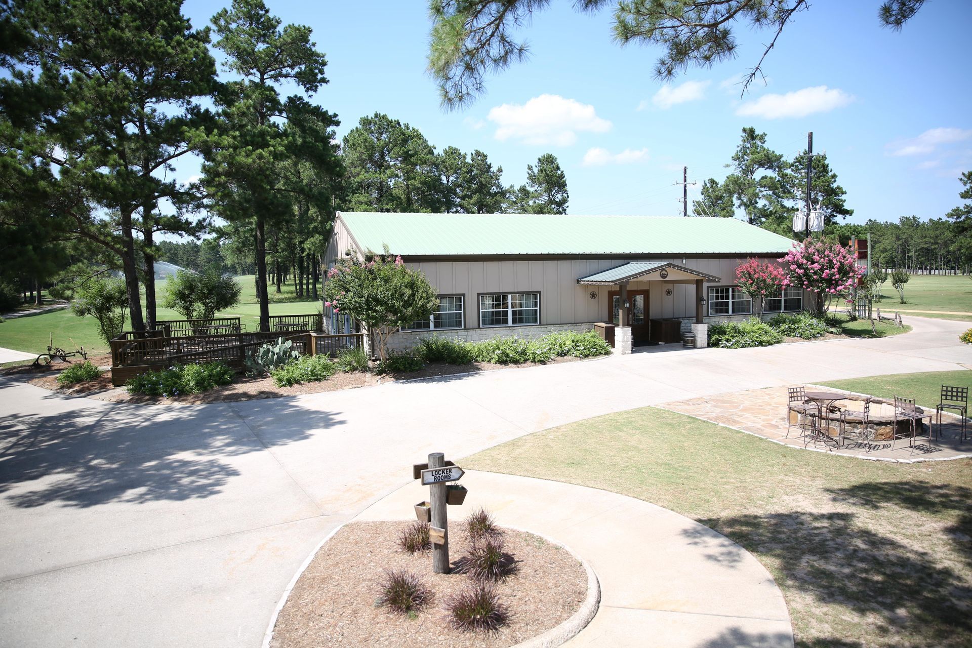 A large building with a green roof is surrounded by trees