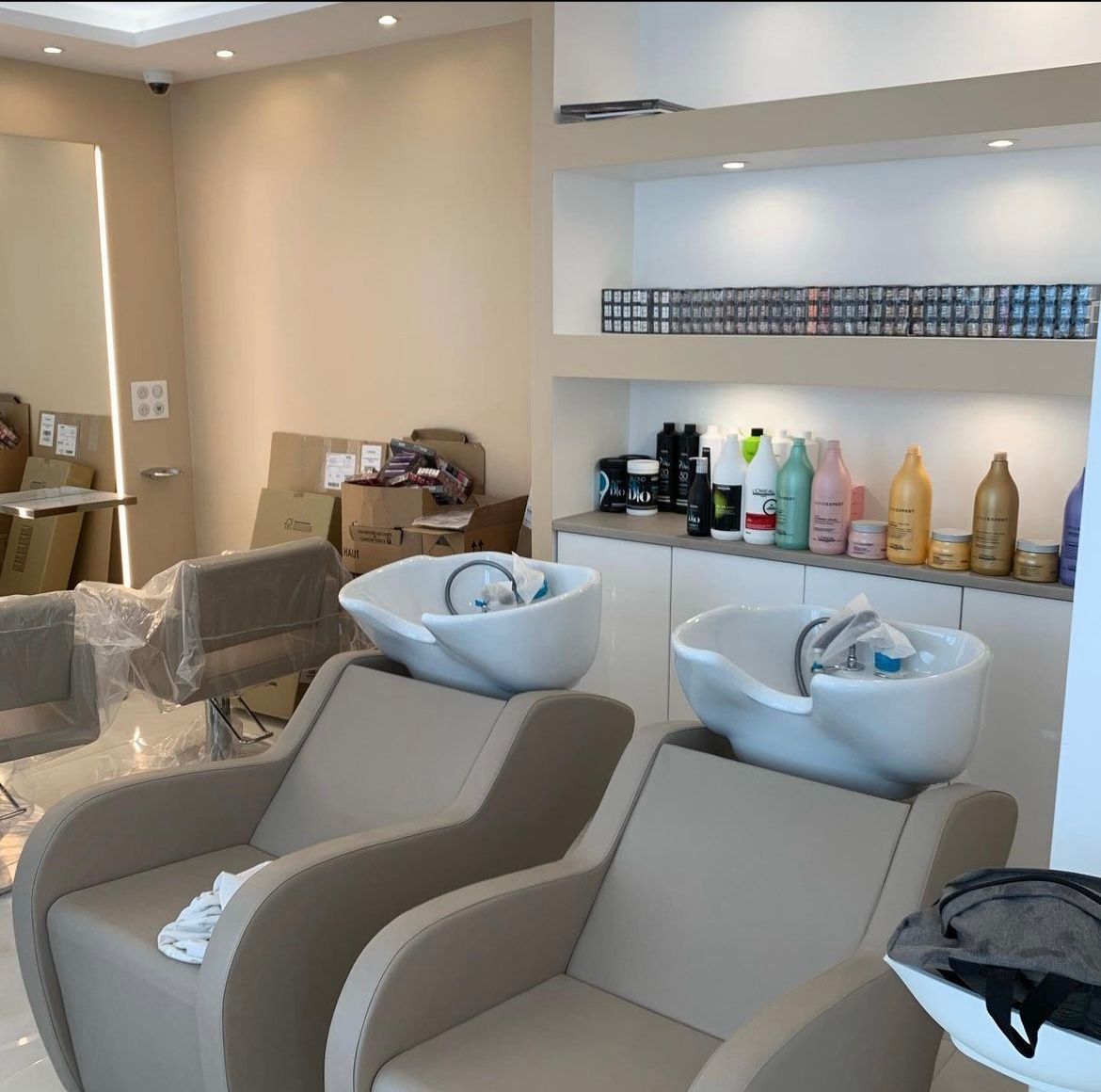 un salon de coiffure avec deux chaises et deux lavabos