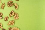 Walnut halves scattered on a light green background.