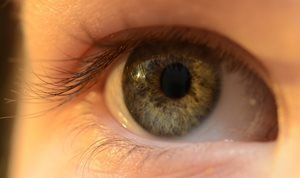 Close-up of a human eye with green and brown hues.