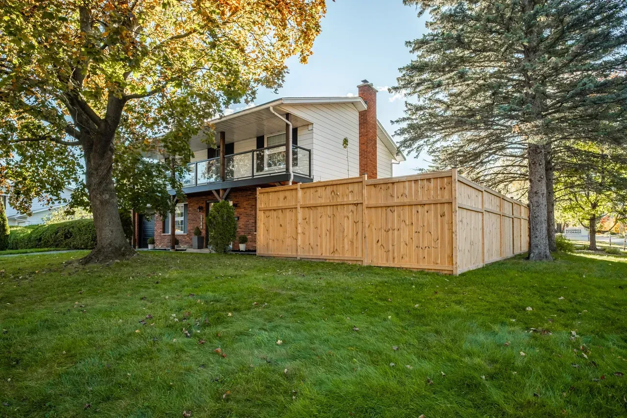A large house with a wooden fence in front of it.