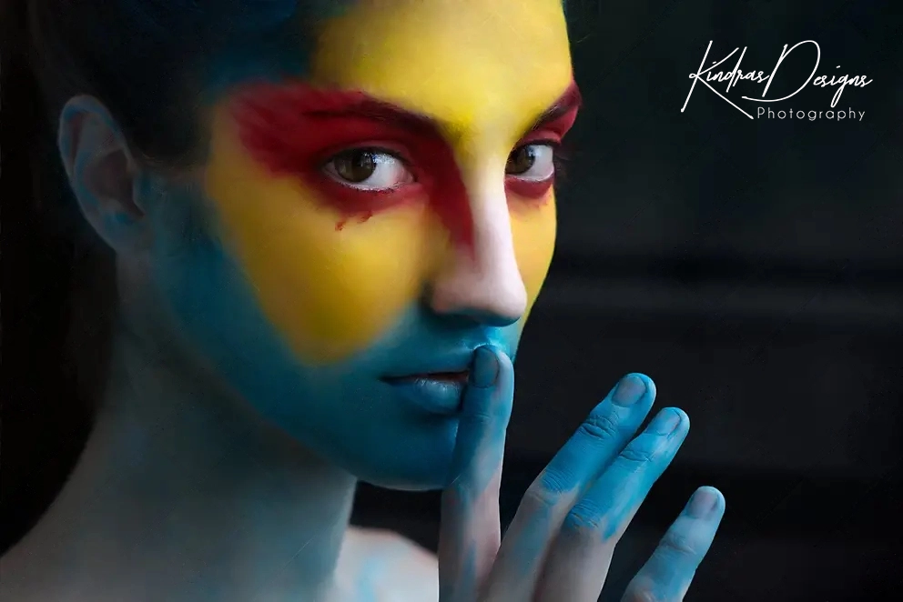 A close up of a woman 's face with colorful paint on it.